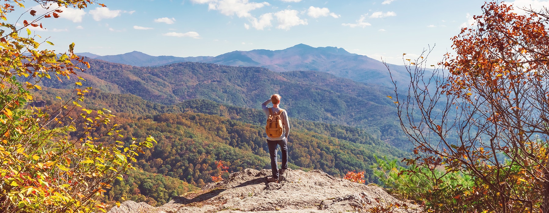 a man standing on the edge of a cliff overlooking a valley